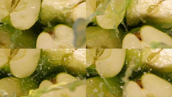 水花以慢动作落在新鲜的青苹果上。多汁的新鲜夏季水果在慢动作中溅出果汁