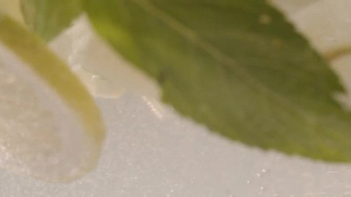 健康冰柠檬饮料排毒倒入玻璃杯中。冰柠檬饮料是一种健康的解毒饮料
