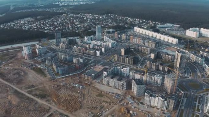 流程建设新邻里顶视图。在开发现场进行空中飞行，在城市街道上建造未完成的房屋和塔式起重机。带有道路和交