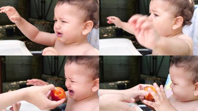 一个小孩坐在婴儿喂奶的椅子上，夏天吃桃子。童年的概念。特写镜头
