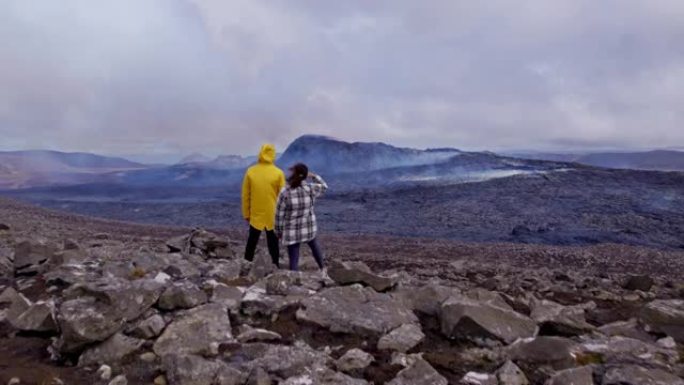 在广阔的岩石场上冒险家的无人机视图中，火山爆发在框架中
