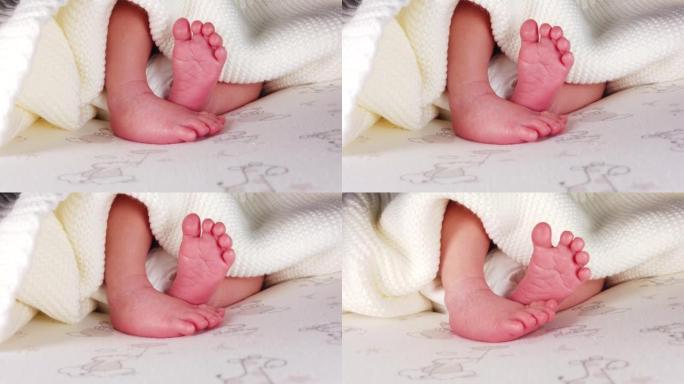 近距离拍摄的新生婴儿躺在尿布和抽搐她的小腿