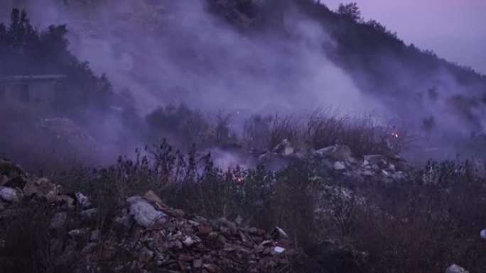 山区森林大火中燃烧的草和成堆的碎屑产生的烟雾
