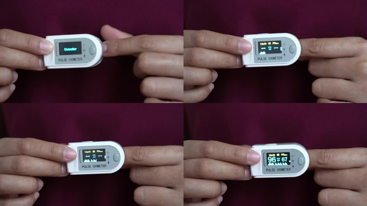 妇女使用血氧计和心率监测仪在手指上的脉搏血氧计在家里新型冠状病毒肺炎，检疫生活方式的概念。
