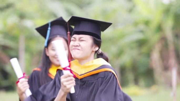 毕业生正在庆祝毕业典礼举手颁发证书，并盖帽庆祝毕业日。