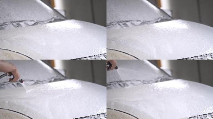 用于消失和清洁的白色泡沫在车身周围流动。化学雪泡沫洗车概念清洁产品。