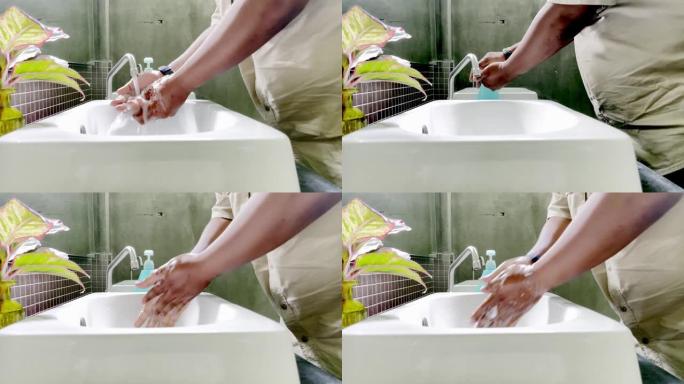 一个大男人在水槽前洗手，以防止在致命的疫情中新型冠状病毒肺炎冠状病毒。