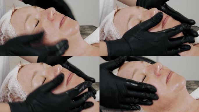 美容疗法。防晒。特写镜头，穿着黑色医用手套的美容师，在中胚层疗法或生物evitalization程序