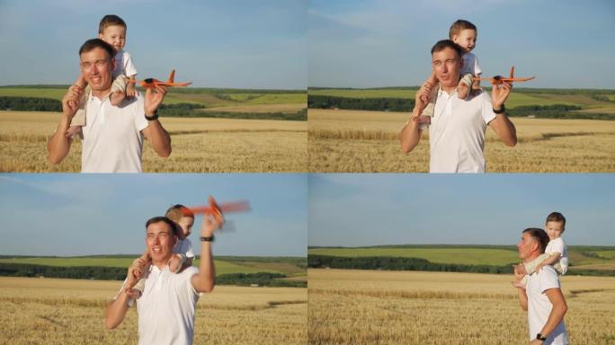 男子将蹒跚学步的儿子扛在肩上，手握玩具飞机