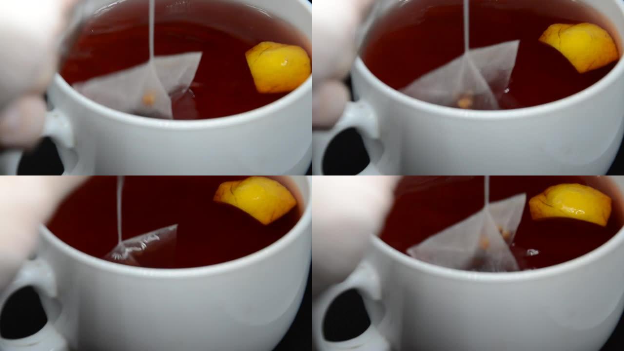 加热的茶冷却并混合在黑色背景上的白色杯子中