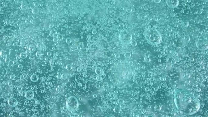 透明化妆品液体凝胶霜中气泡的宏观拍摄。带有气泡的蓝色化妆液质地。慢动作