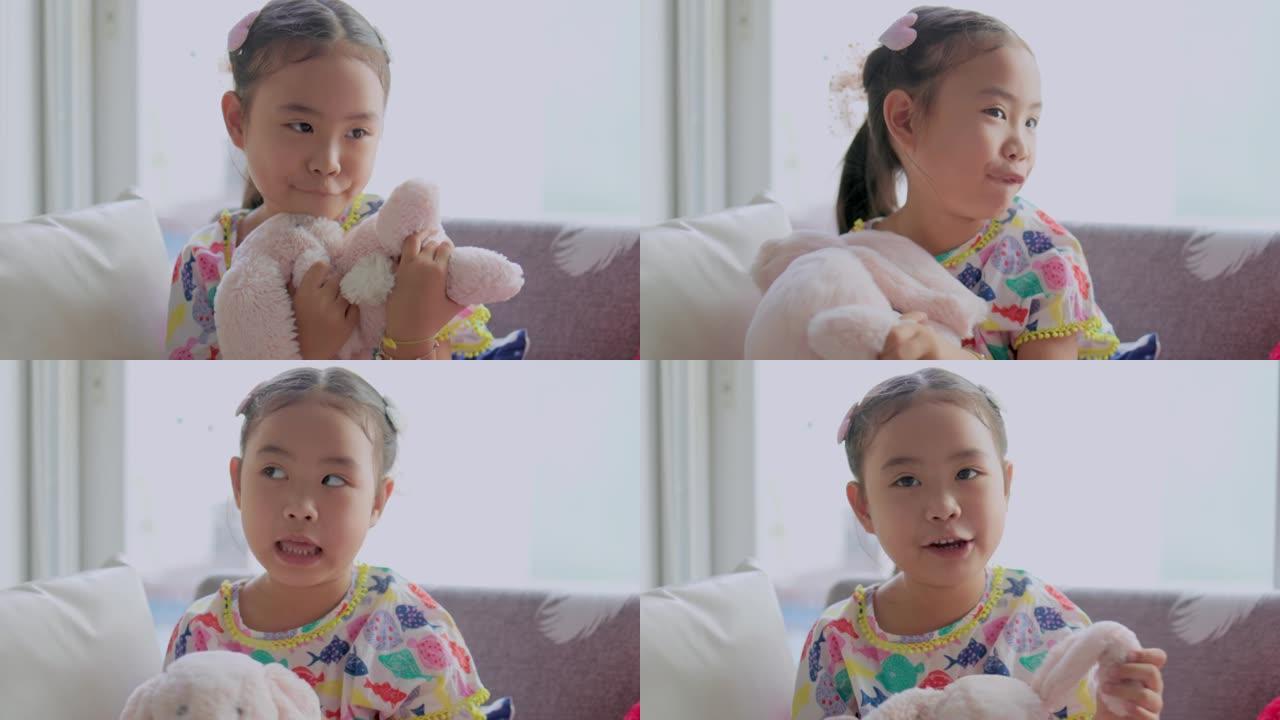 玩粉色兔子娃娃的亚洲女孩。