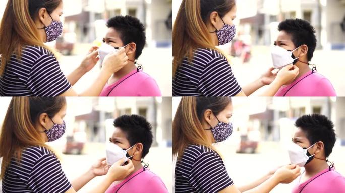 母亲戴着口罩给儿子，以防止冠状病毒新型冠状病毒肺炎的传播