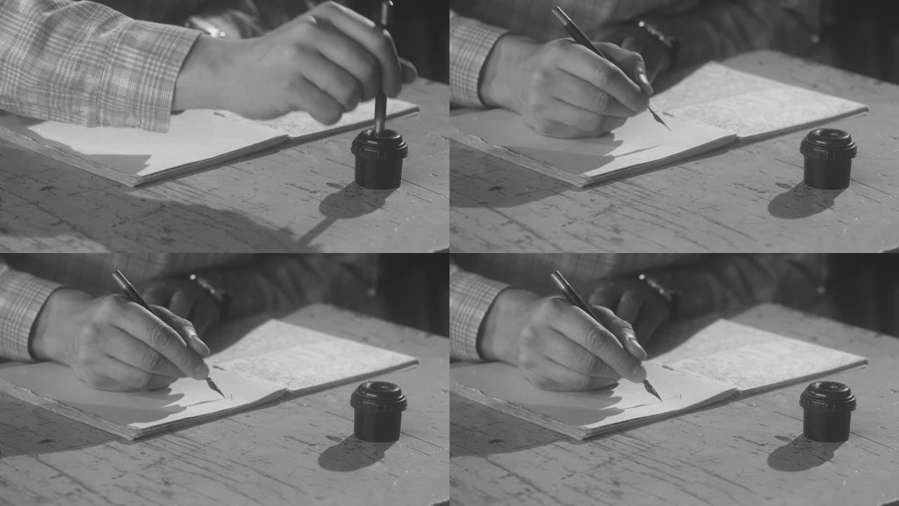 男子坐在办公桌前，用复古钢笔和墨水做笔记。库存镜头。男性的手将笔浸入墨水中，并开始在纸质笔记本上写东