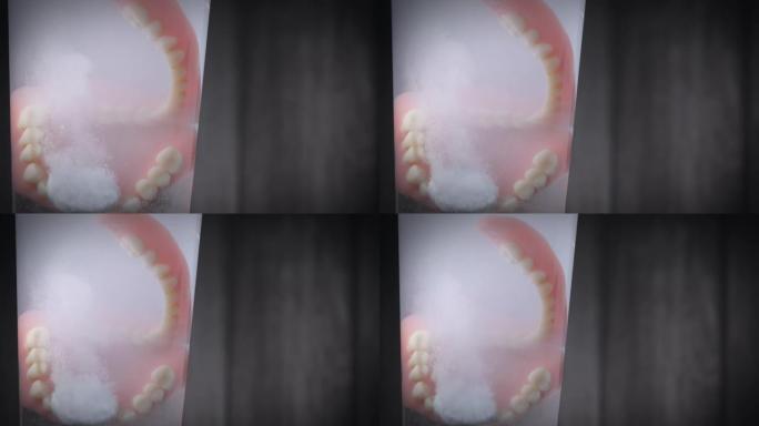 用溶解片剂清洁假体牙齿的特写镜头。