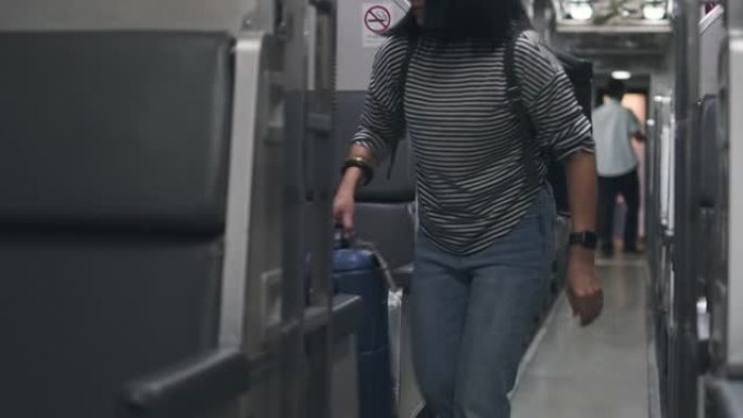 亚洲妇女带着手提箱在火车上的人行道上行走