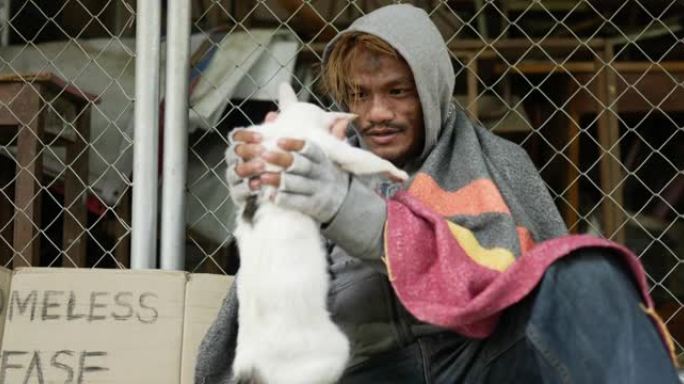 无家可归的人抱着猫玩