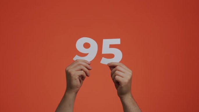 九十五号在手。显示数字的人，95个由雕刻纸制成的数字，用于投票，数学学习或销售