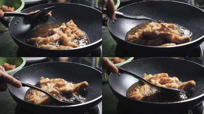 香肠在装满沸腾油的锅中煎炸。脆皮和垃圾食品菜单。泰国美味的菜单。特写镜头。