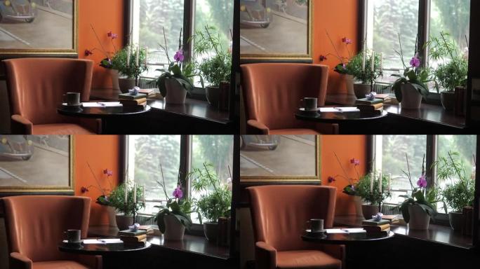 咖啡馆里的一张空桌子，附近有一把橙色的椅子。桌子上的书和一张皱巴巴的纸。