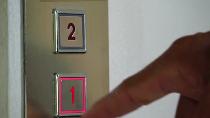 镜头4K: 男子在电梯中按下按钮