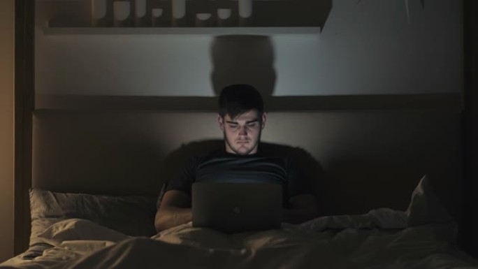 深夜工作在线晚上乏力家伙笔记本电脑在床上