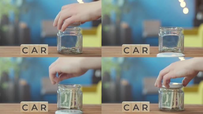 汽车是写在桌子上的木制立方体上的单词。手把钱放在附近的罐子里。积累大量资金进行大额购买的概念