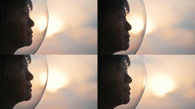 亚洲华裔女宇航员从太空飞船上透过窗户看地球日出