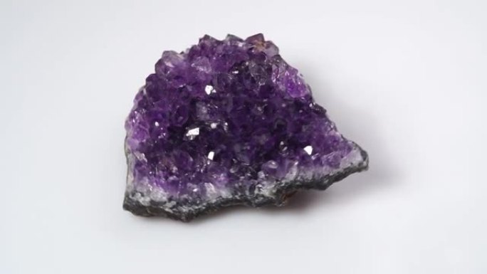白色背景上的天然紫水晶druzy旋转