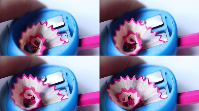 从蓝色卷笔刀移动的木制粉色铅笔刨花的特写视图