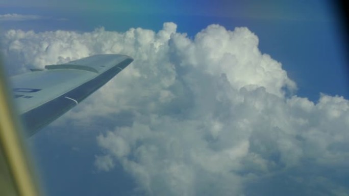 窗户上云层上方的飞机机翼视图