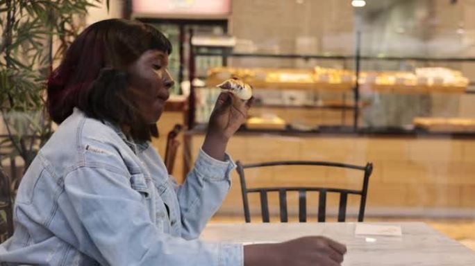 黑人妇女在面包店吃甜早餐