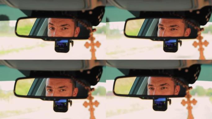 一名年轻人的眼睛在汽车后视镜中反射