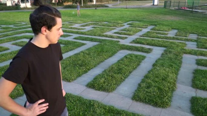一个十几岁的男孩环顾真人大小的迷宫，说明了生活迷宫和青少年的选择。