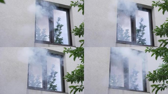 房子着火了。烟雾从窗户冒出来