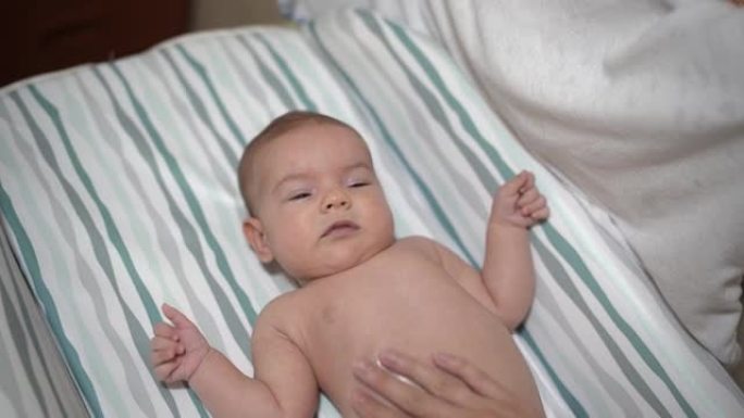 躺在床上的新生婴儿正在按摩肚子