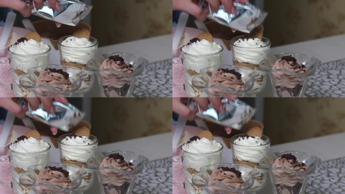 一名妇女装饰用奶油和饼干屑制成的甜点。特写镜头。