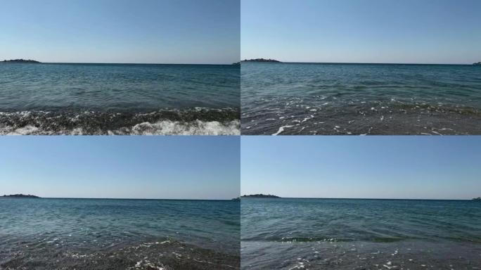 在旅游爱琴海小镇 “Sigacik” 的 “Akarca” 海滩上的爱琴海小浪的镜头。这是土耳其伊兹