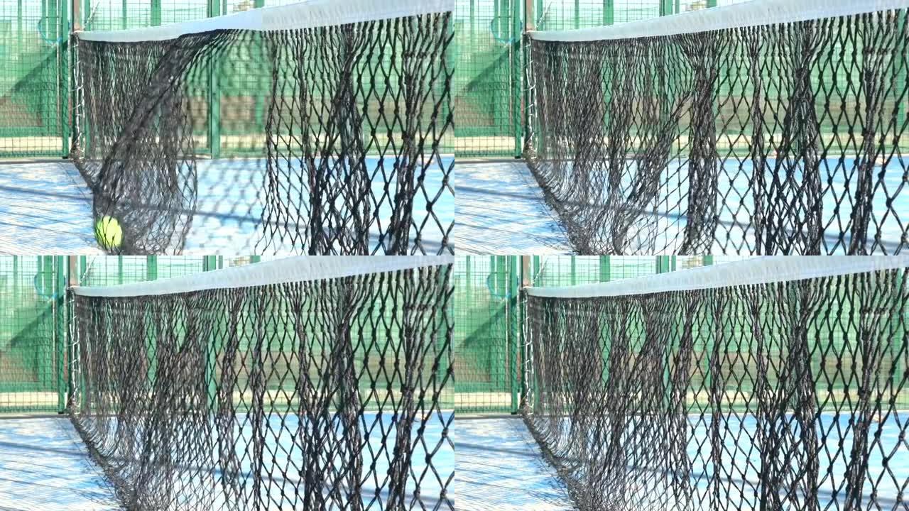 球的慢动作击中室外桨网球场的网。