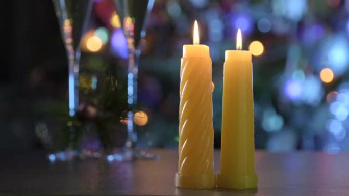 装饰房间的桌子上燃烧蜡烛，背景是圣诞树。浪漫的圣诞之夜，在神奇的气氛中庆祝寒假