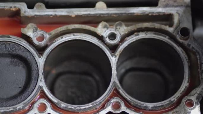 在机械师的修理中拆卸了汽车的发动机。四缸发动机的气缸体。特写