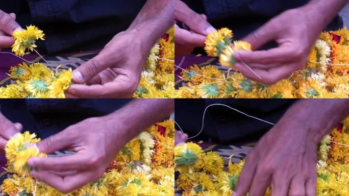 一个人制作花环和装饰辫子结或花，叶子或其他材料的花环的稳定镜头。