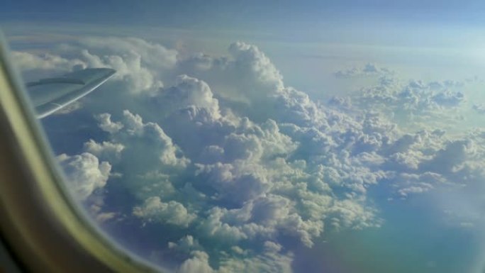 从飞机窗口观看地面上方的云层