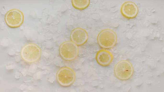柠檬片掉落并与冰一起跳跃，用于夏季补品和天然苏打水汁