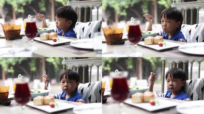 一个在餐馆吃饭的小男孩