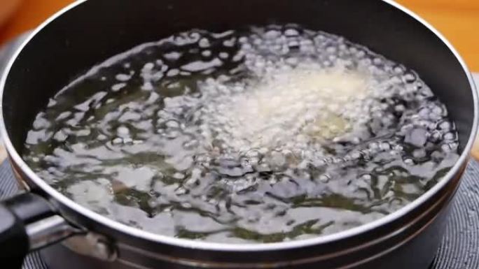 香肠串涂上面糊，用热油在厨房炉子上的平底锅里油炸。自制玉米狗。烹饪过程。