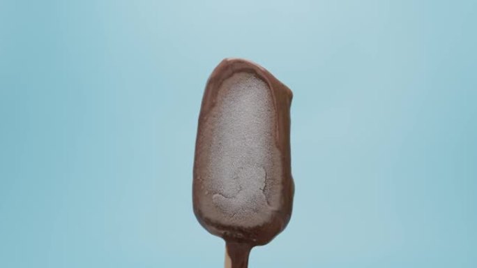 冰棒棒巧克力融化在蓝色背景上。