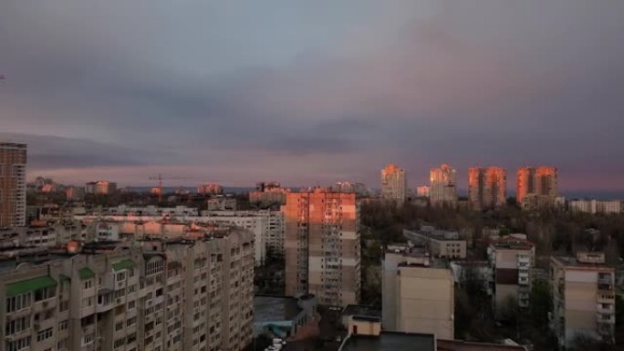 在日落的黄金时刻，城市景观上的灰色天空中的紫云