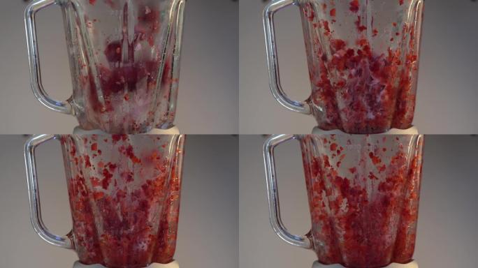 搅拌器的玻璃容器，其中将红色的成熟草莓水果和糖捣碎。健康有机食品。