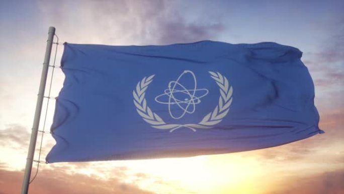 国际原子能机构的旗帜在风，天空和太阳背景下挥舞